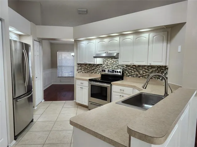 a kitchen with a stove a refrigerator and a sink