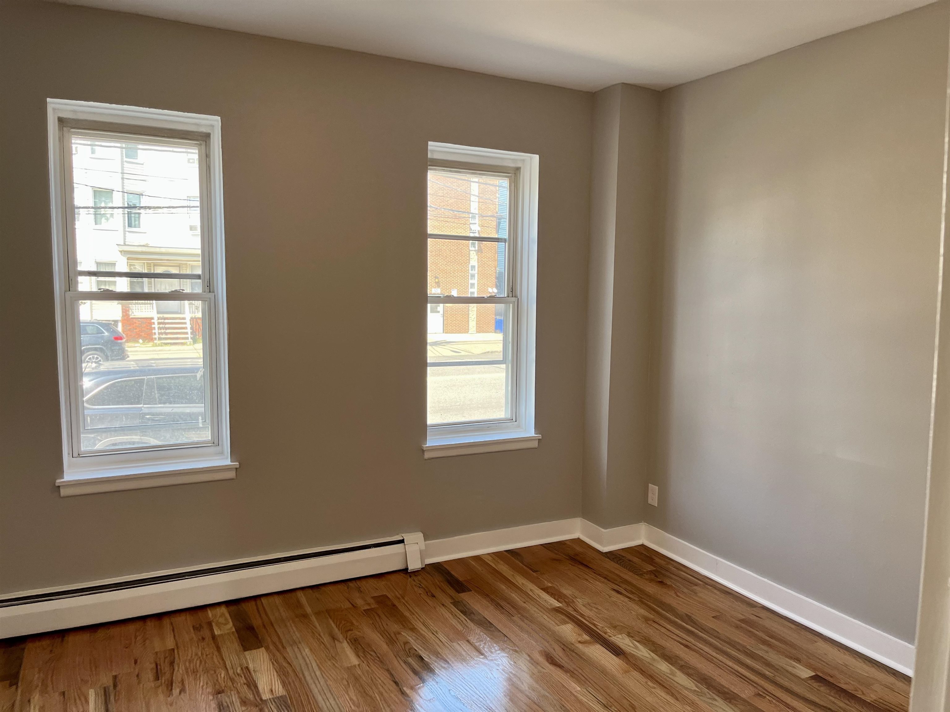 514 John F. Kennedy Boulevard, Unit 1 Bayonne, NJ 07002 - Photo 5 of 7 a view of an empty room with wooden floor and a window