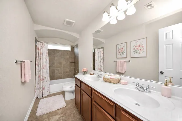 a spacious bathroom with a double vanity sink mirror and toilet