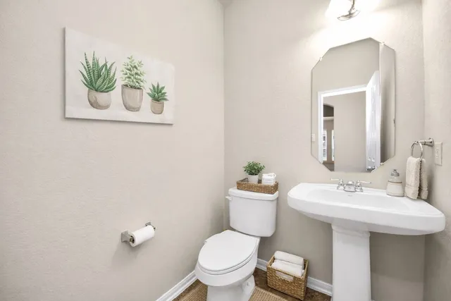 a bathroom with a toilet a sink and mirror