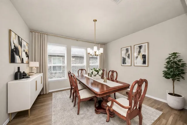 a dining room with furniture a chandelier and wooden floor