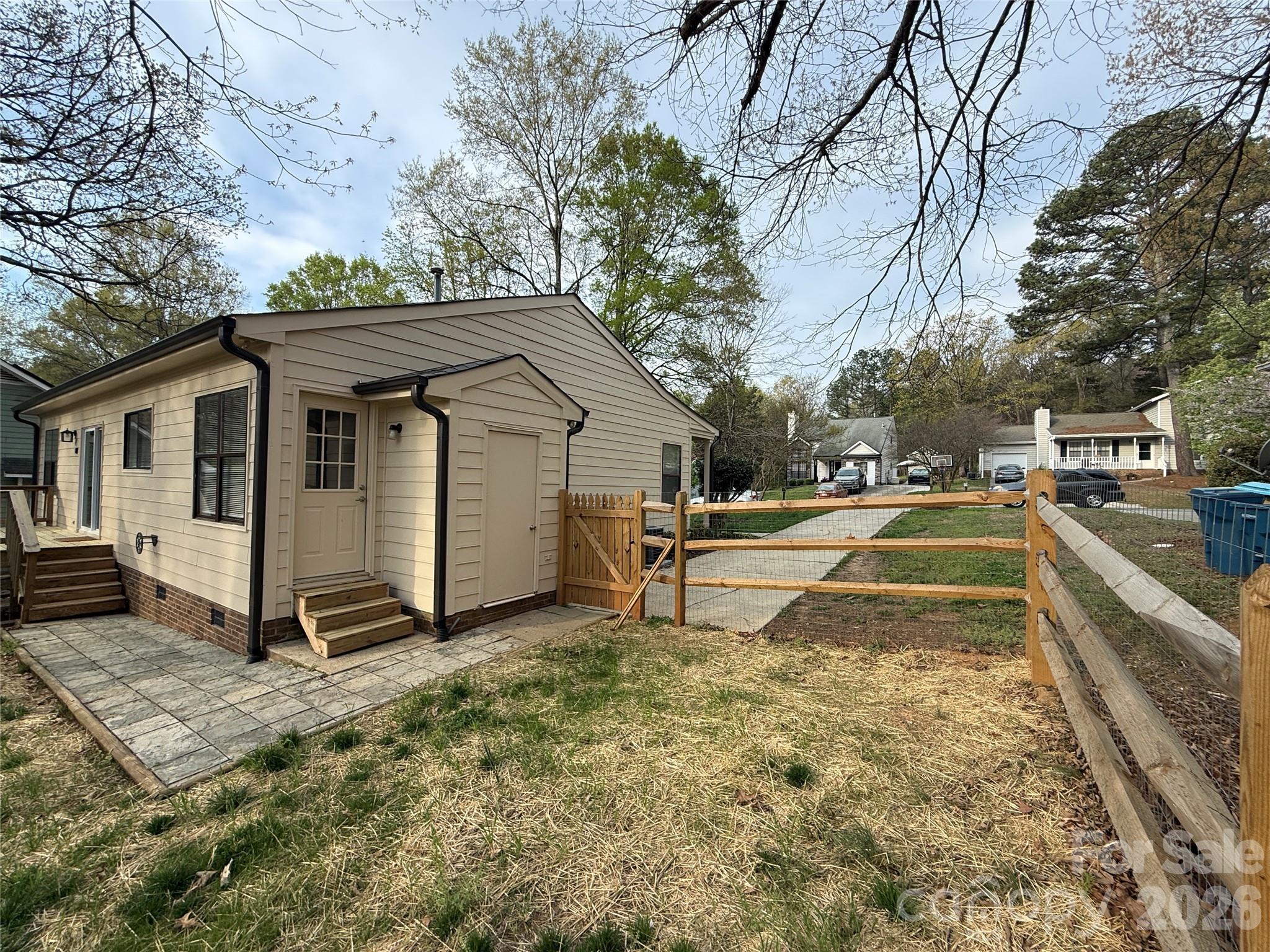 10129 Rockwood Road Charlotte, NC 28215 - Photo 30 of 36 a view of a white house with a yard and sitting area