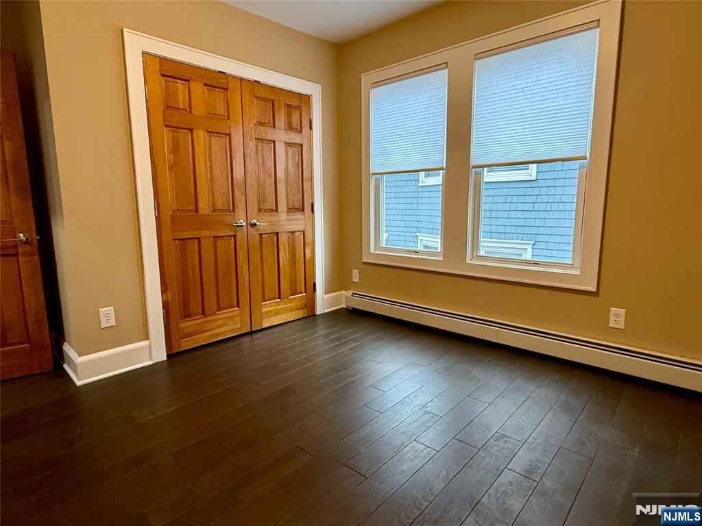 59 Laurel Avenue, Unit RIGHT SIDE Kearny, NJ 07032 - Photo 10 of 16 an empty room with wooden floor and windows