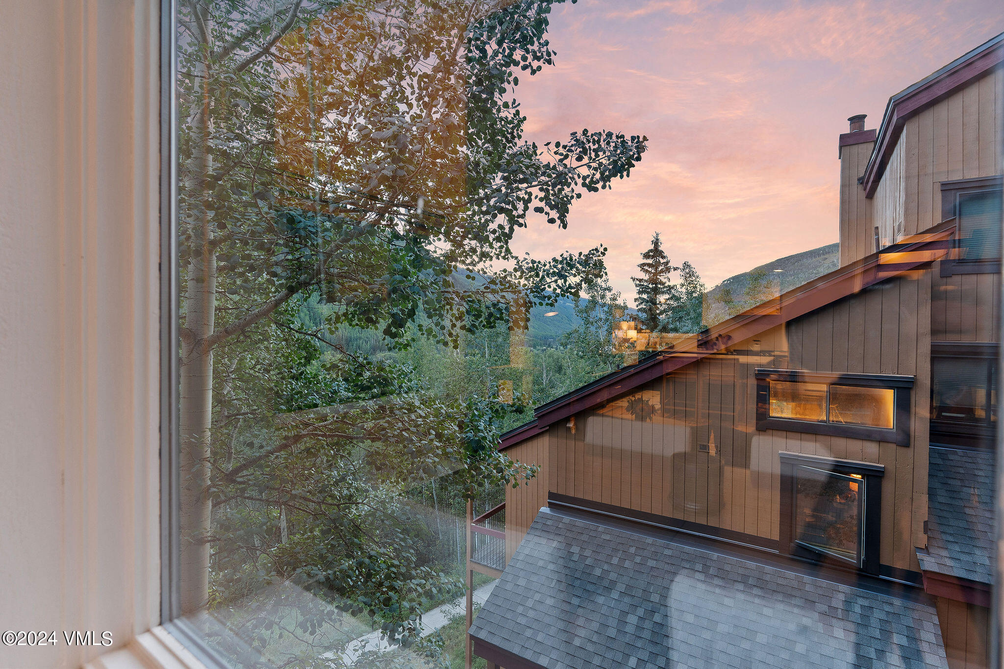 3094 Booth Falls Road, Unit 14 Vail, CO 81657 - Photo 30 of 36 a blue house with trees in the background