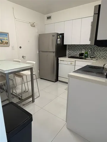 a kitchen with a refrigerator sink stove and cabinets