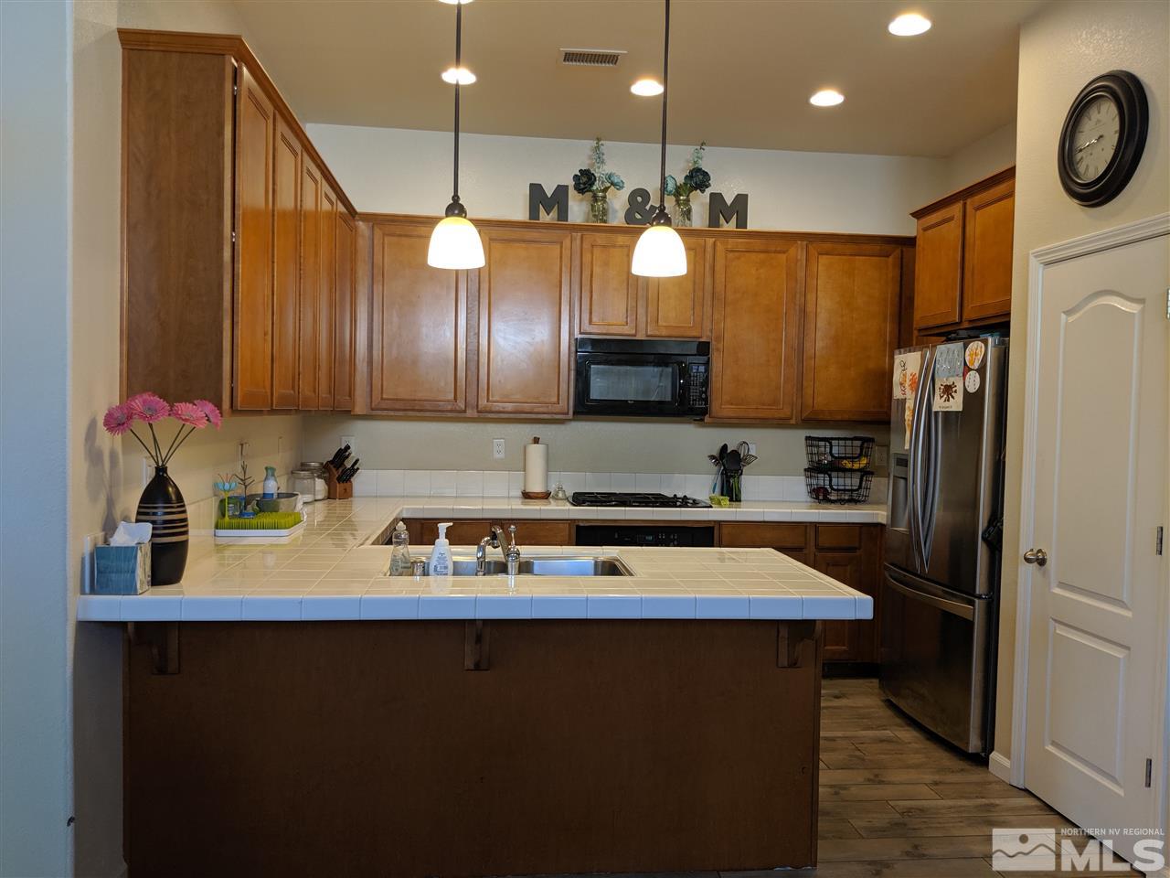 420 Pesaro Way Reno, NV 89521 - Photo 7 of 25 a kitchen with stainless steel appliances granite countertop a sink refrigerator and cabinets