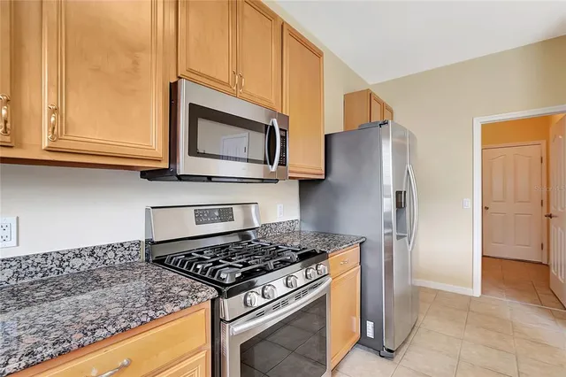 a kitchen with stainless steel appliances granite countertop a stove microwave and refrigerator