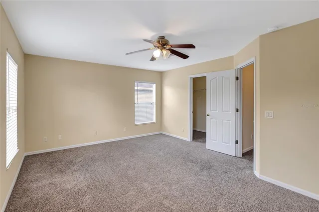 a view of a room with a ceiling fan and closet