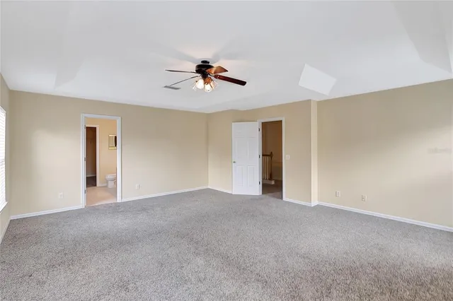 a view of a big room with windows and chandelier fan