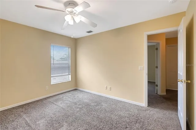a view of an empty room with a chandelier fan