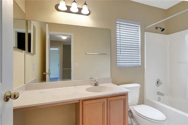 an empty room with a chandelier fan and windows