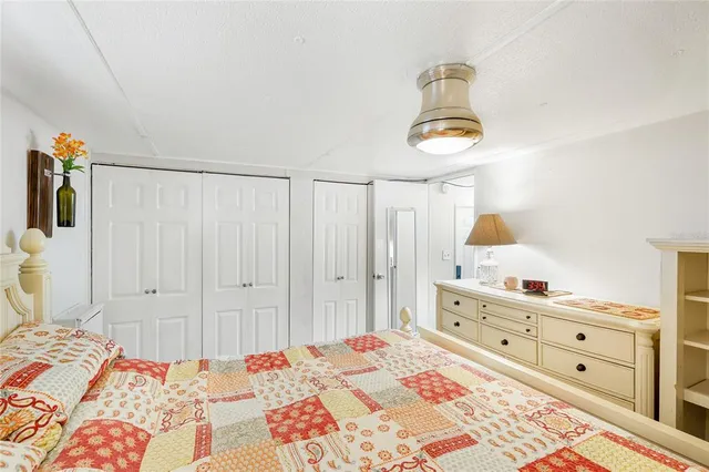 a bedroom with a bed and a lamp on dresser