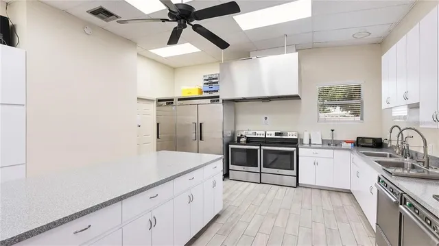 a kitchen with stainless steel appliances granite countertop a sink a stove and cabinets
