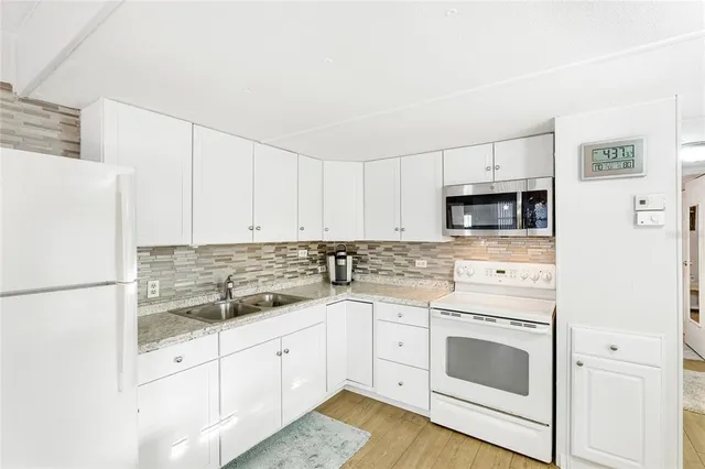 a kitchen with white cabinets and white appliances