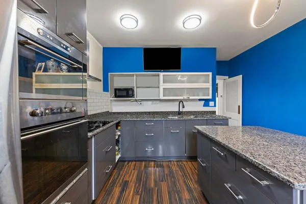a kitchen with stainless steel appliances granite countertop a stove a sink and a microwave