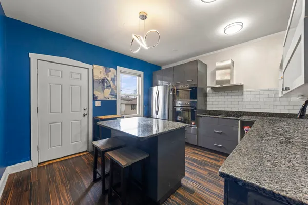a kitchen with granite countertop a sink cabinets and wooden floor
