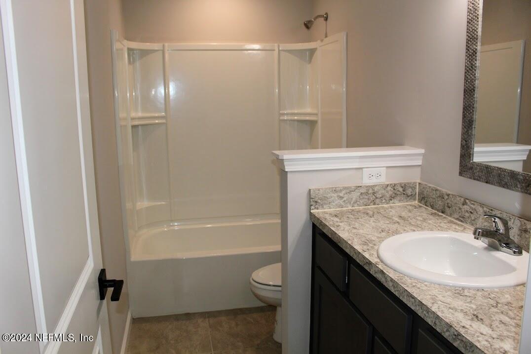 4152 Quiet Creek Loop, Unit 134 Middleburg, FL 32068 - Photo 18 of 42 a bathroom with a granite countertop sink toilet and shower