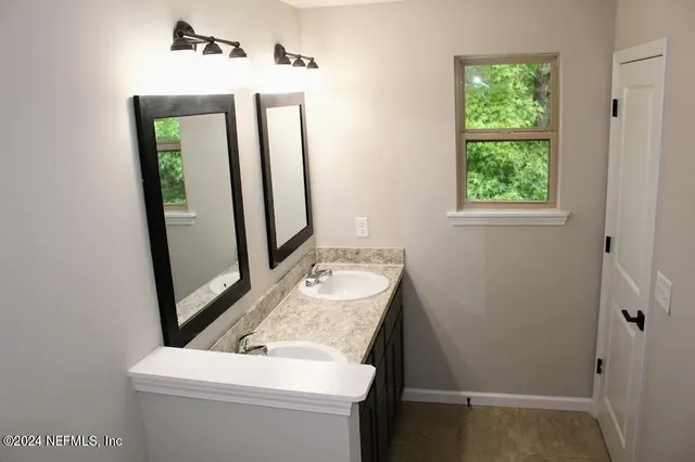 a bathroom with a sink a toilet and mirror