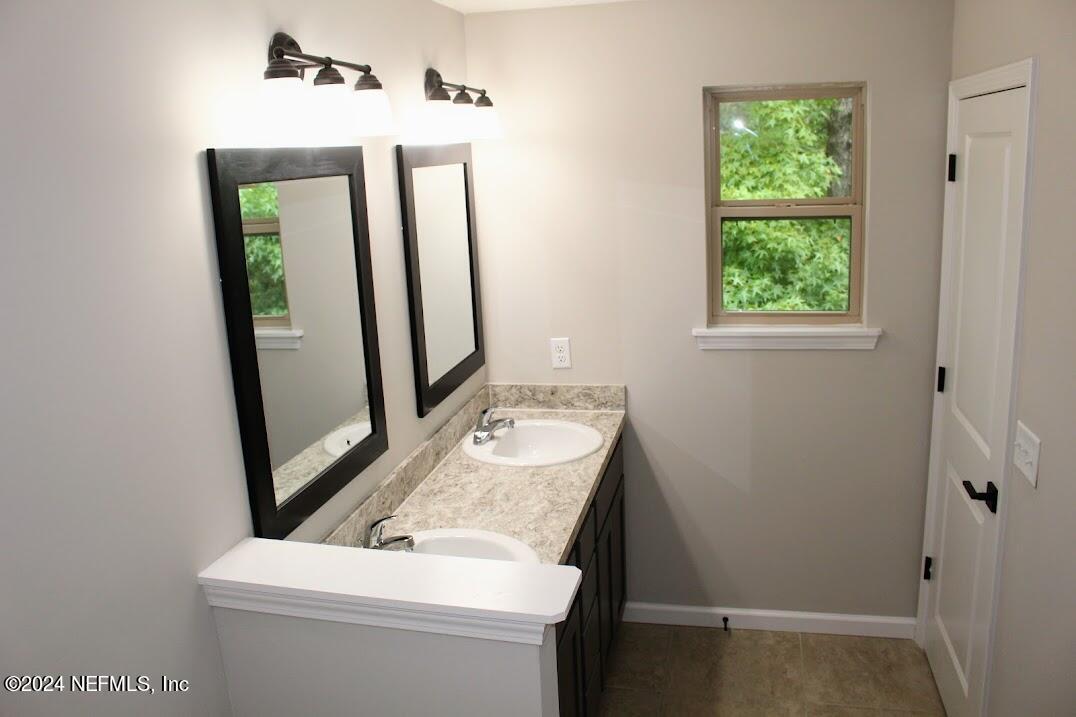 4152 Quiet Creek Loop, Unit 134 Middleburg, FL 32068 - Photo 21 of 42 a bathroom with a sink a toilet and mirror