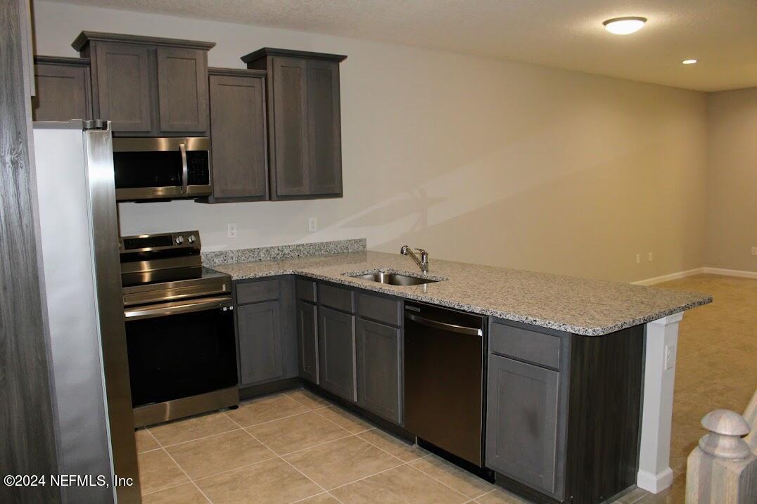 4152 Quiet Creek Loop, Unit 134 Middleburg, FL 32068 - Photo 3 of 42 a kitchen with stainless steel appliances granite countertop a sink stove and refrigerator
