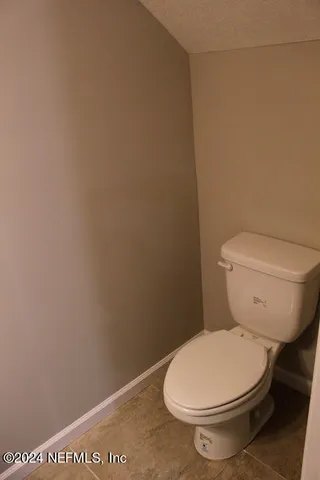 a white toilet sitting next to a white wall