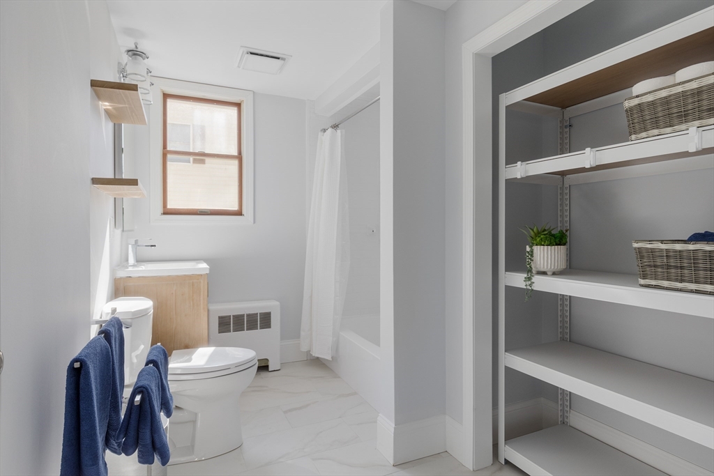 56 Spring Street, Unit 56 Cambridge, MA 02141 - Photo 12 of 14 a bathroom with a toilet a sink and a window