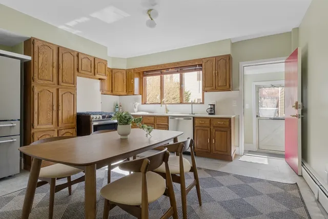 a kitchen with a table chairs refrigerator and microwave