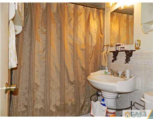 123 Winthrop Road Edison, NJ 08817 - Photo 14 of 22 a bathroom with a sink a mirror and a toilet