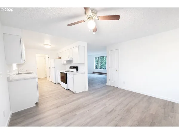 a view of kitchen with granite countertop cabinets and refrigerator