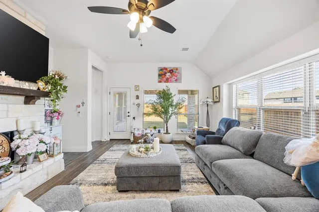 a living room with furniture flat screen tv and a large window