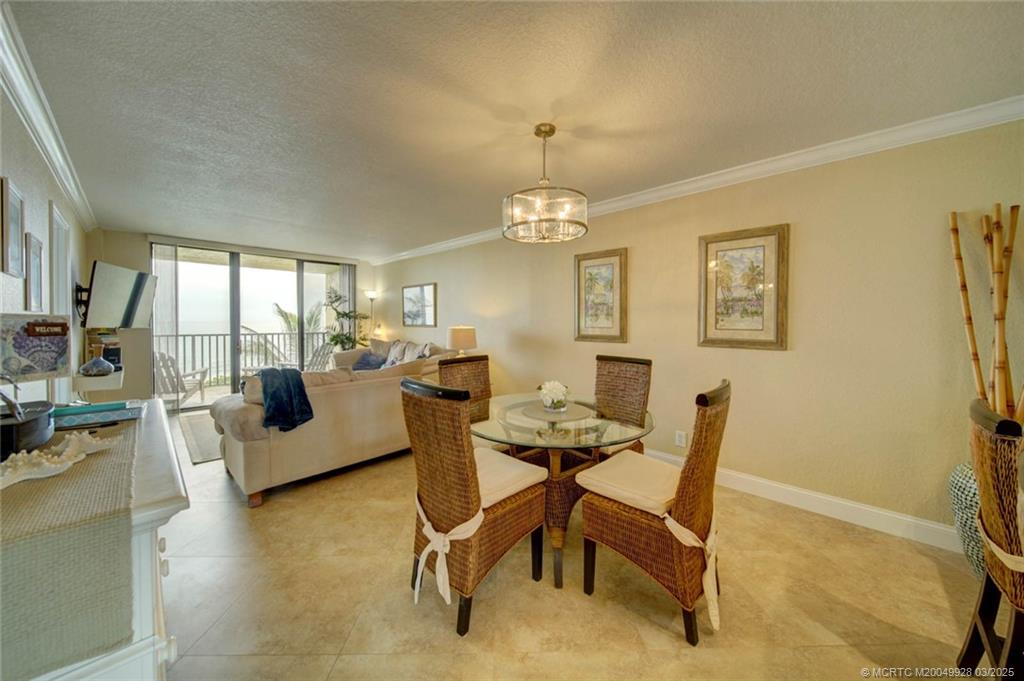 7380 South Ocean Drive, Unit 320 Jensen Beach, FL 34957 - Photo 11 of 39 a living room with furniture and a chandelier