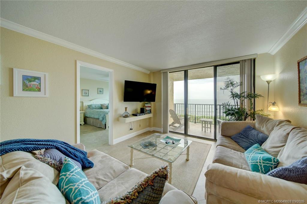7380 South Ocean Drive, Unit 320 Jensen Beach, FL 34957 - Photo 15 of 39 a living room with furniture and a flat screen tv