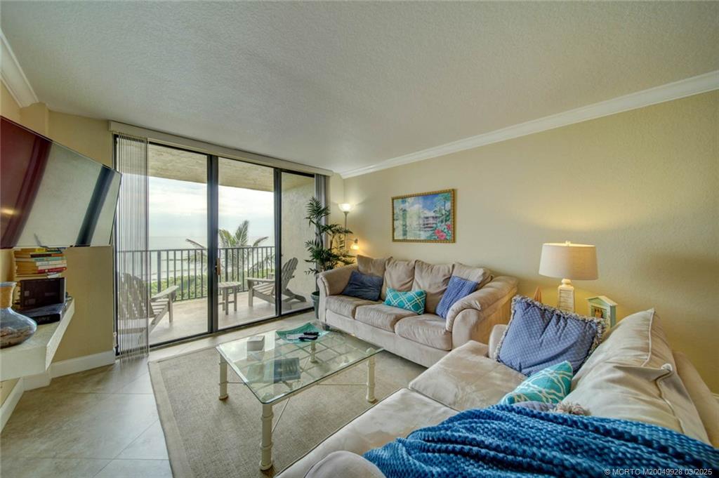 7380 South Ocean Drive, Unit 320 Jensen Beach, FL 34957 - Photo 16 of 39 a living room with furniture and a floor to ceiling window