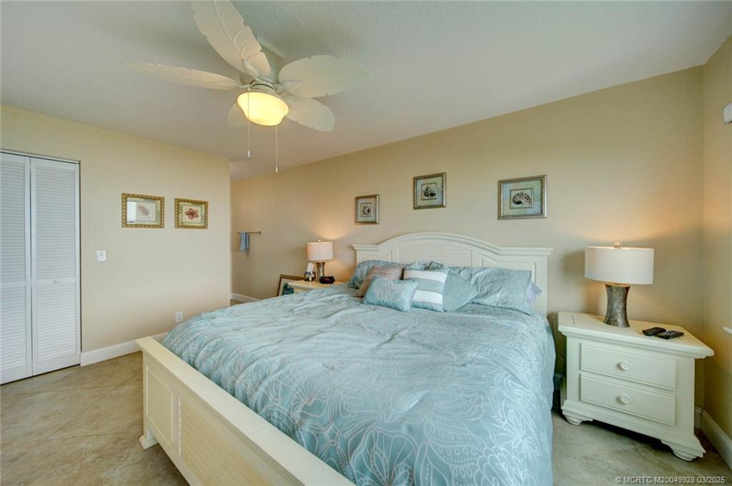 7380 South Ocean Drive, Unit 320 Jensen Beach, FL 34957 - Photo 21 of 39 a bedroom with a bed and a lamp on dresser