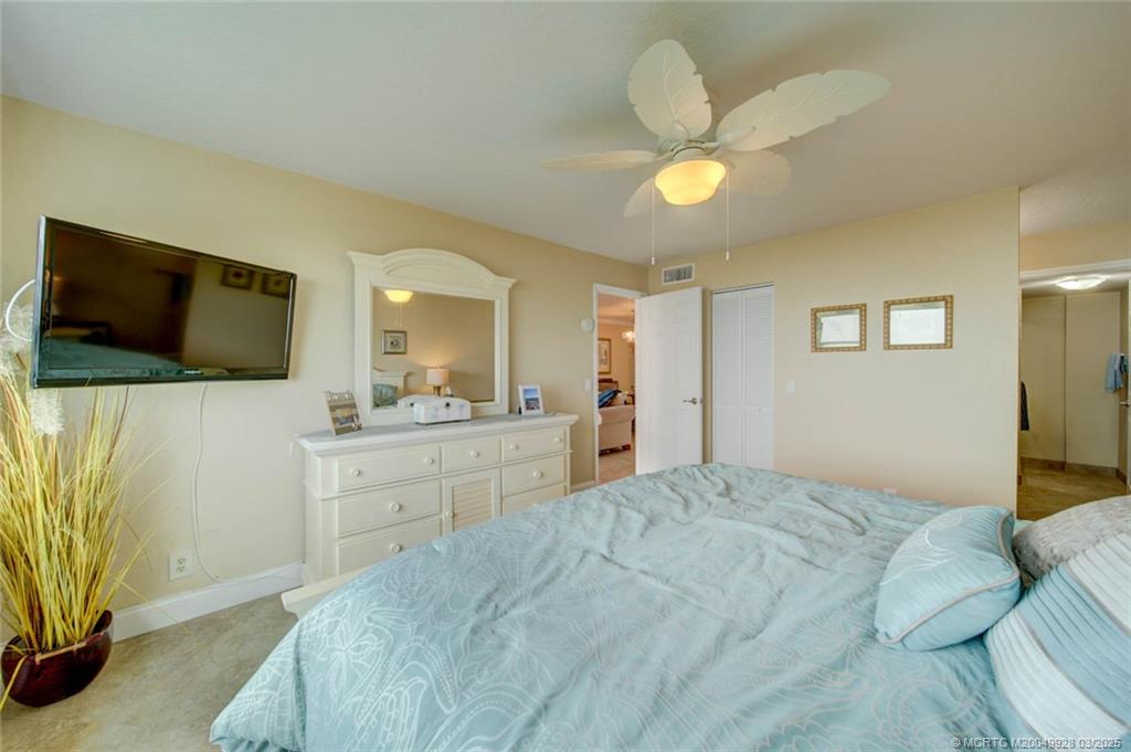 7380 South Ocean Drive, Unit 320 Jensen Beach, FL 34957 - Photo 22 of 39 a bedroom with a bed and a flat tv screen on dresser