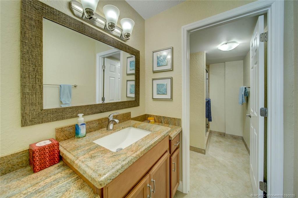 7380 South Ocean Drive, Unit 320 Jensen Beach, FL 34957 - Photo 23 of 39 a bathroom with a sink vanity and mirror