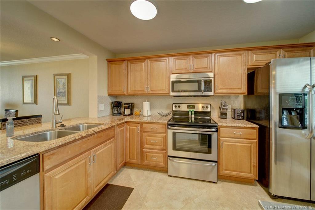 7380 South Ocean Drive, Unit 320 Jensen Beach, FL 34957 - Photo 8 of 39 a kitchen with stainless steel appliances granite countertop a stove a sink and a microwave