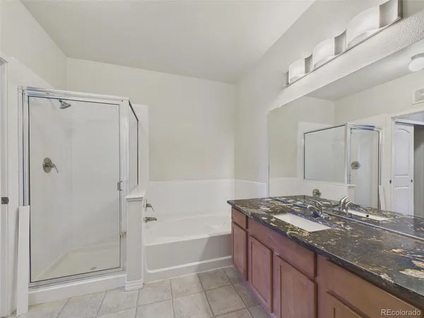 a bathroom with a granite countertop sink a mirror and a bathtub