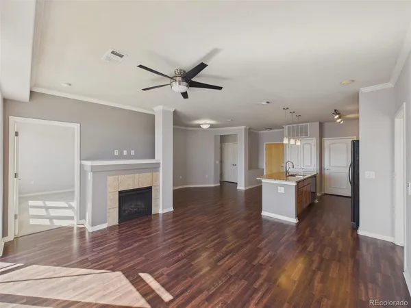 a view of a hallway with wooden floor and a kitchen