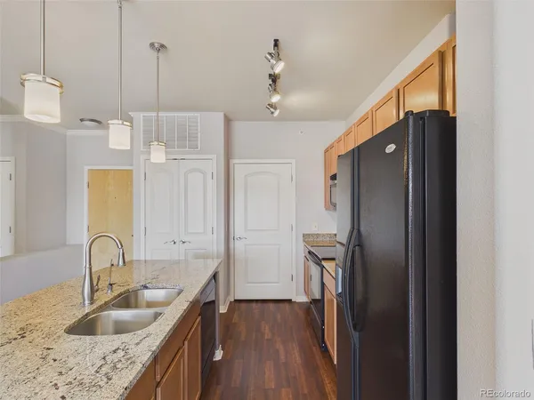 a kitchen with stainless steel appliances granite countertop a refrigerator a sink and a stove