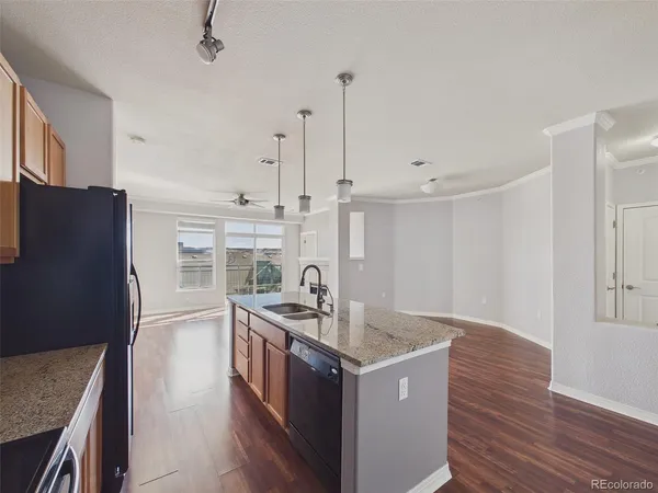 a kitchen with stainless steel appliances granite countertop a sink a stove and a refrigerator