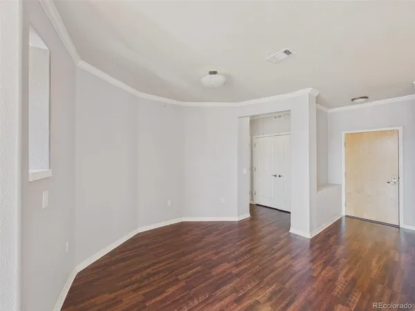 a view of an empty room with wooden floor