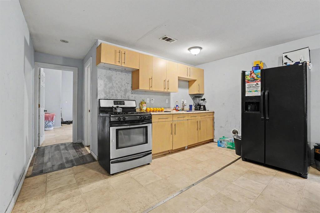 205 South Main Street Bonham, TX 75418 - Photo 5 of 23 a kitchen with a refrigerator and a stove top oven