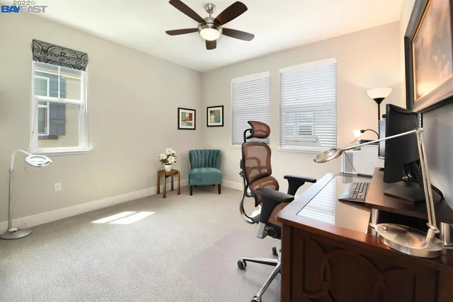 a view of a workspace with furniture and a window