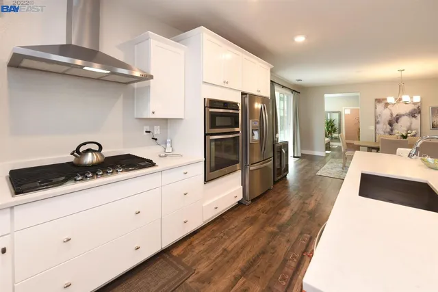 a large kitchen with stainless steel appliances kitchen island granite countertop a sink and cabinets