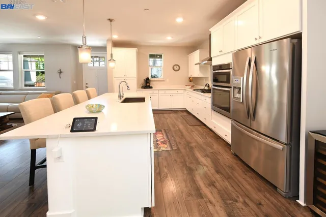 a large kitchen with a refrigerator a stove a sink dishwasher with a dining table and chairs