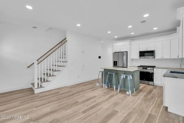 a kitchen with white cabinets and stainless steel appliances