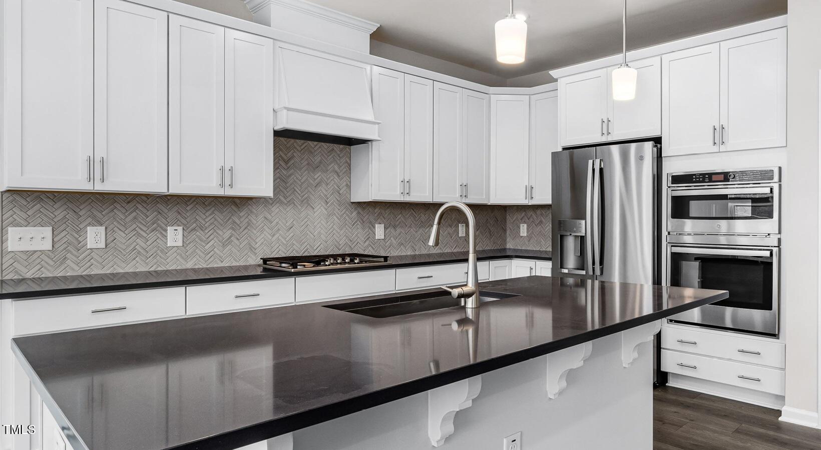 3709 Nova Star Lane, Unit GRADY Raleigh, NC 27612 - Photo 17 of 30 a kitchen with stainless steel appliances granite countertop a sink a stove and a refrigerator with white cabinets