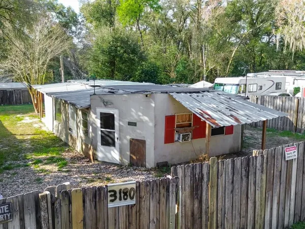 a view of a house with a wooden fence