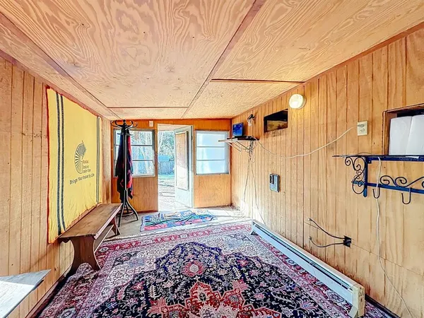 a view of a bedroom with wooden floor and windows